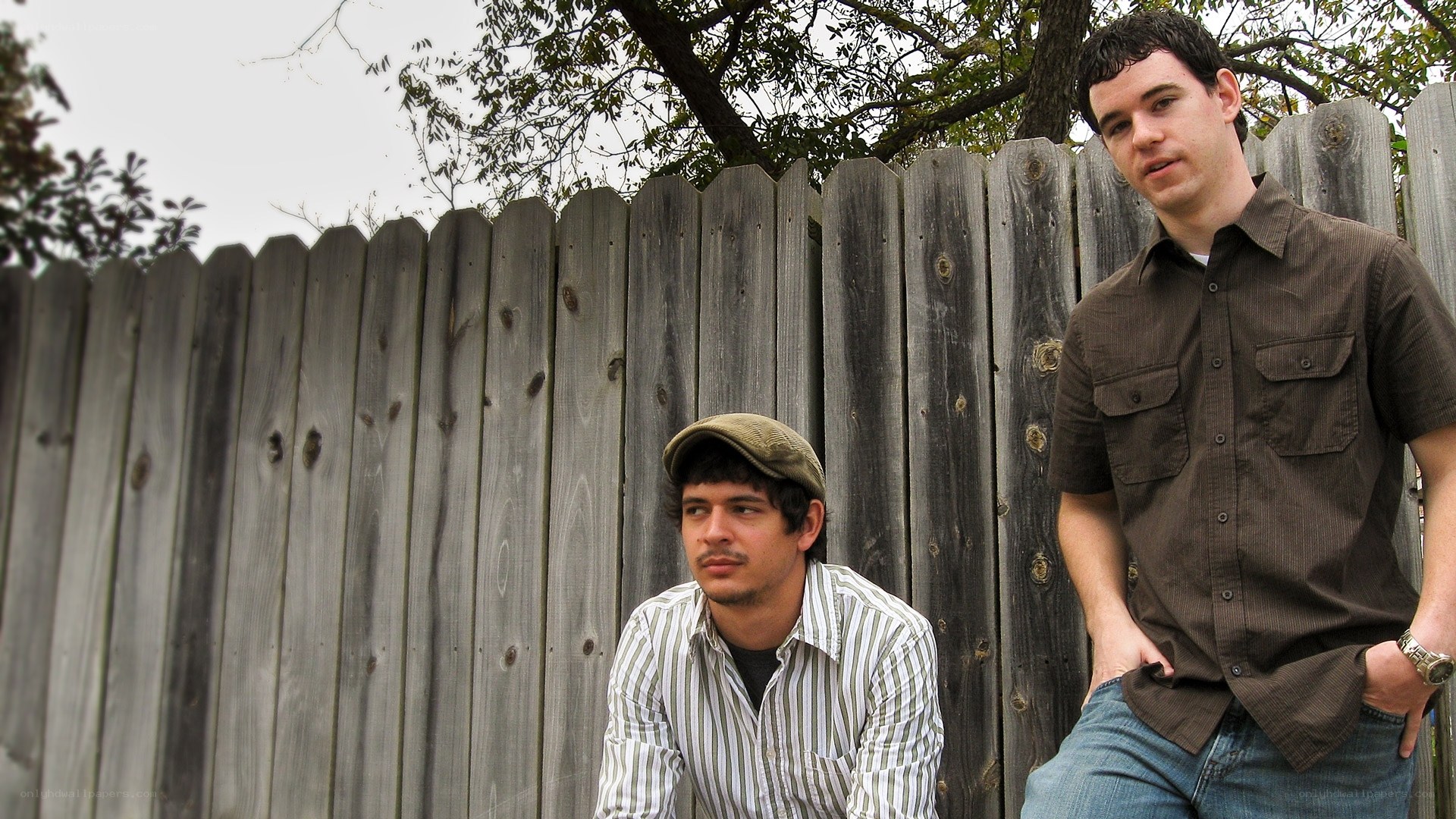 two men by a wooden fence