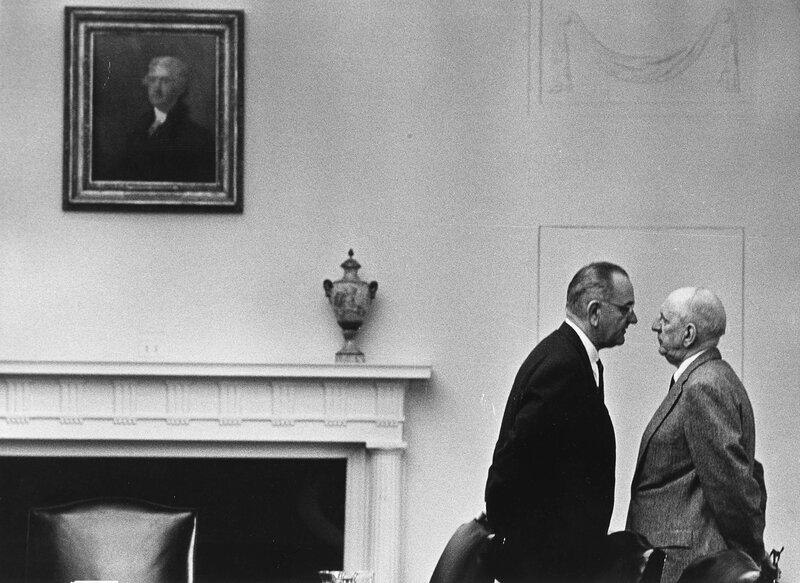 Two men conversing in a formal room