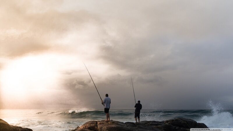 Two Men Fishing on Rocks
