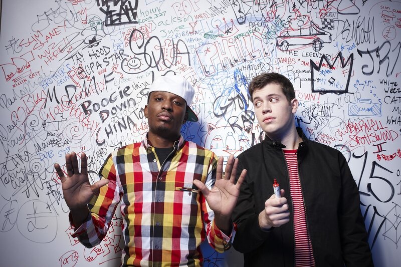 two men in front of graffiti wall