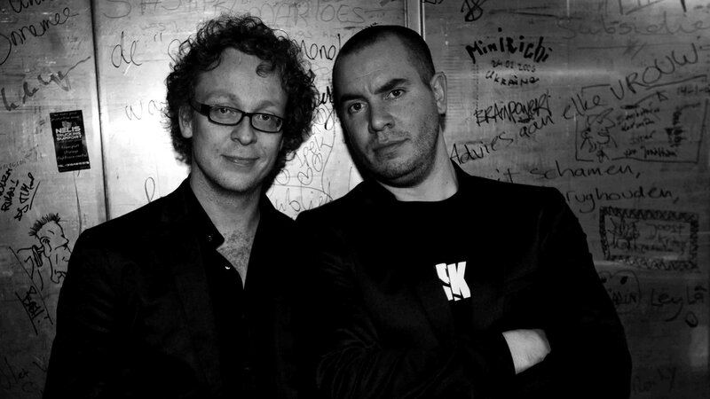 two men in front of graffiti wall