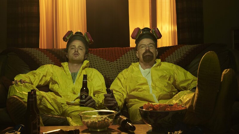 Two men in hazmat suits on a couch