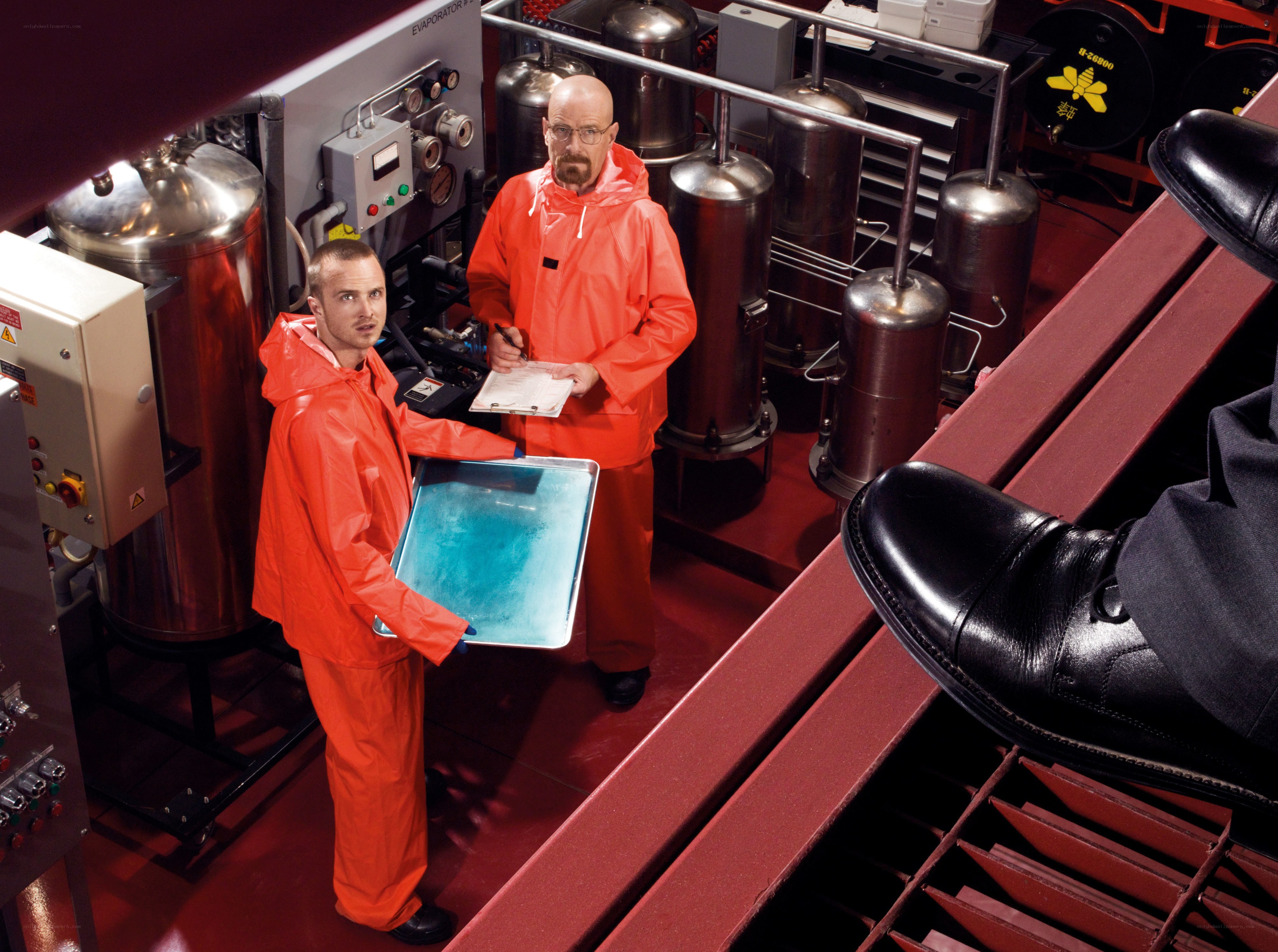 Two men in orange suits in a lab