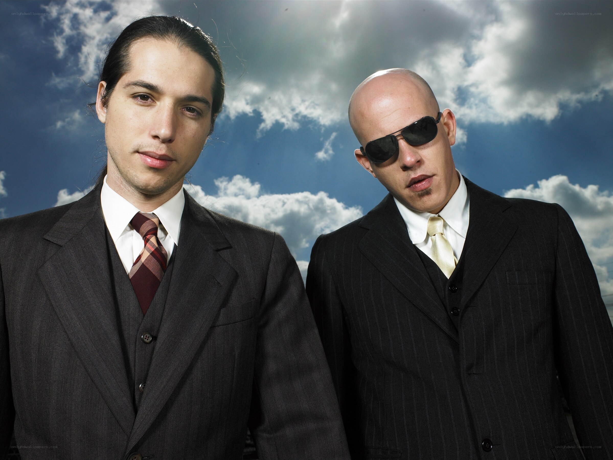 two men in suits against sky
