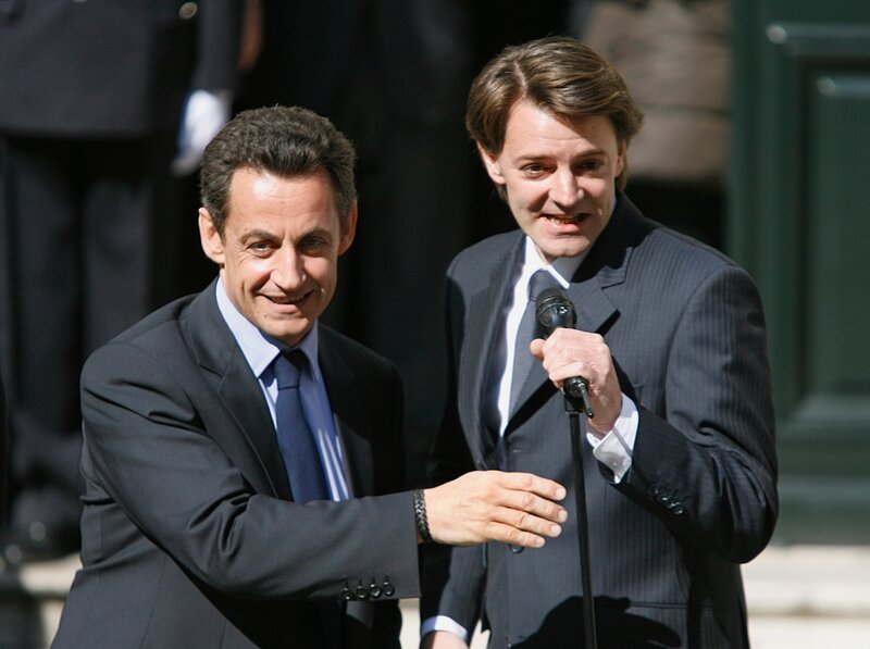 two men in suits at podium