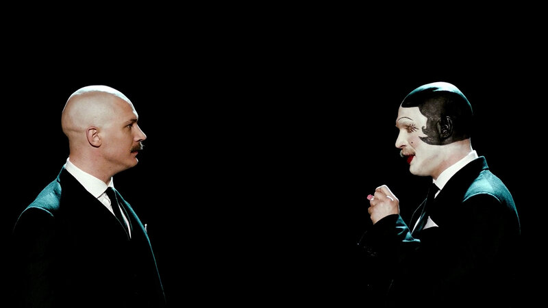 Two men in suits facing each other