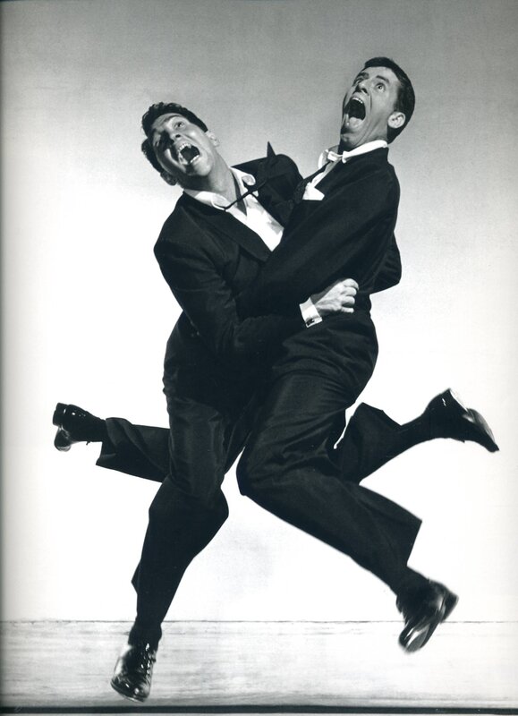 Two men in suits jumping