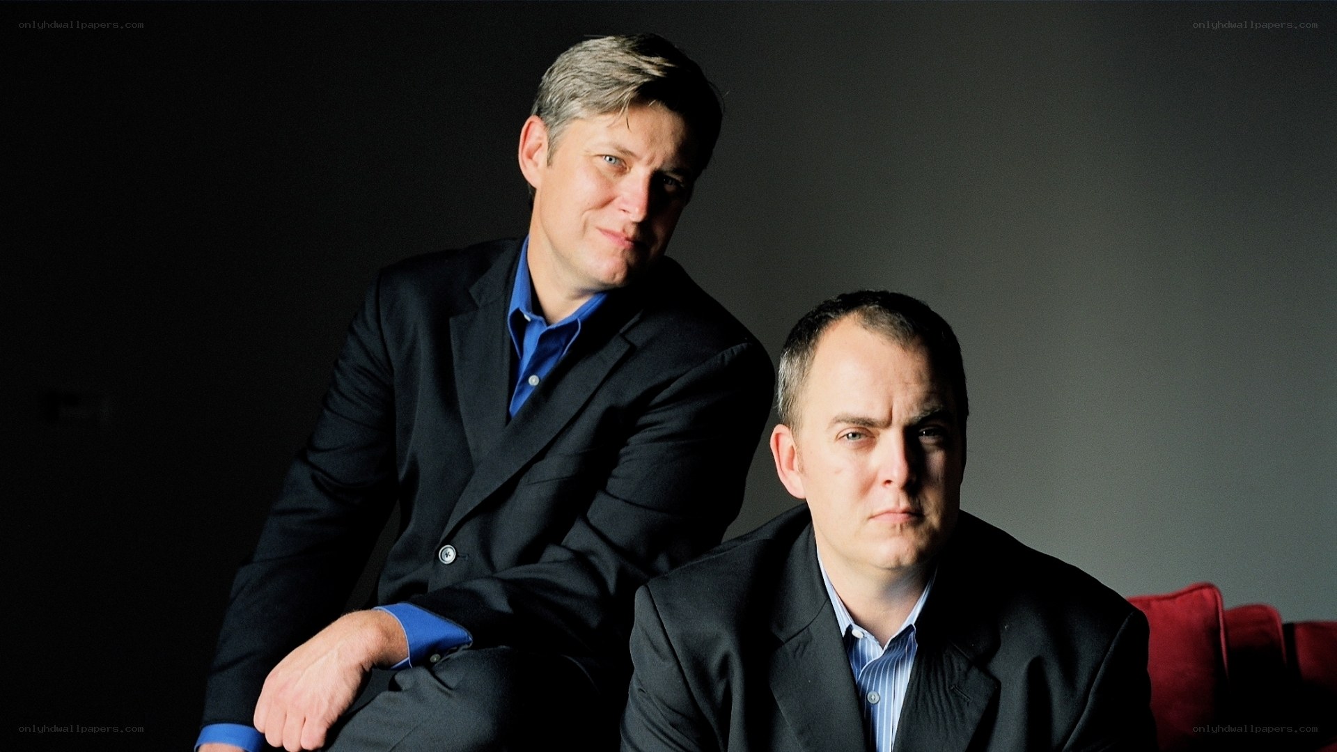 two men in suits on a couch
