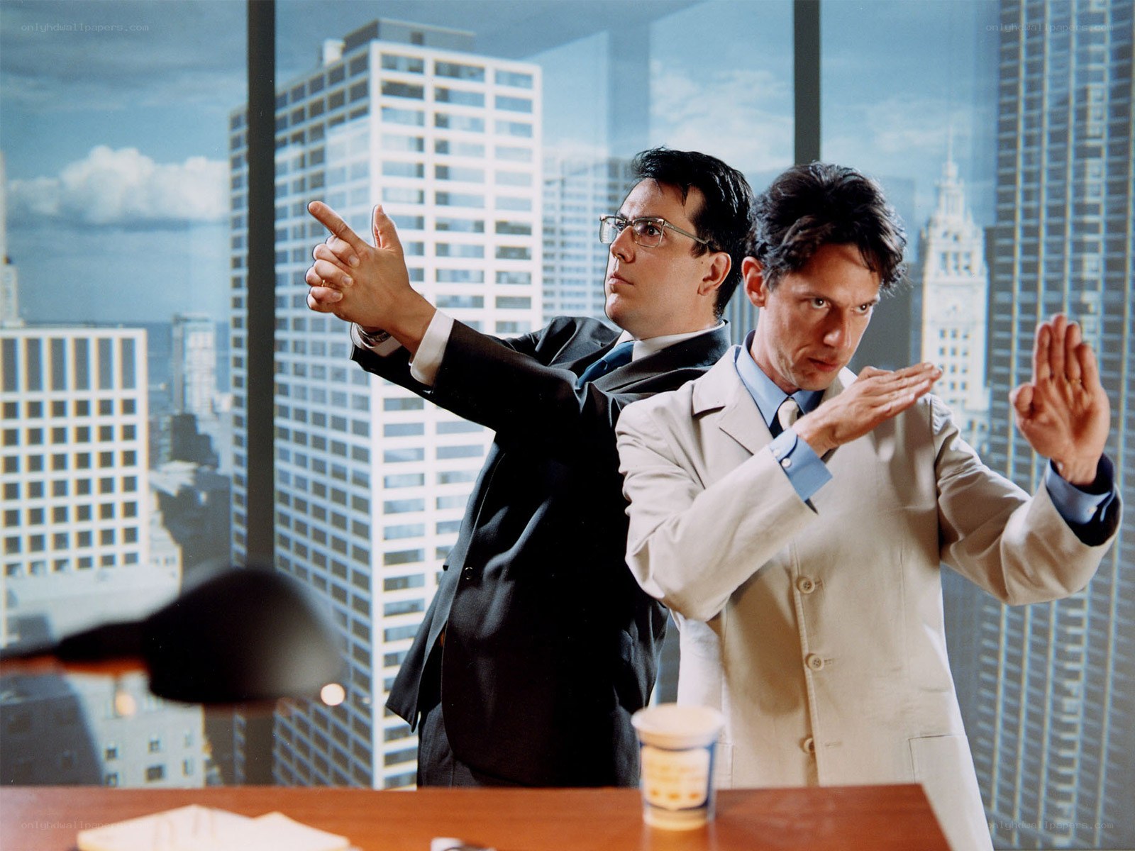 Two men in suits posing in office