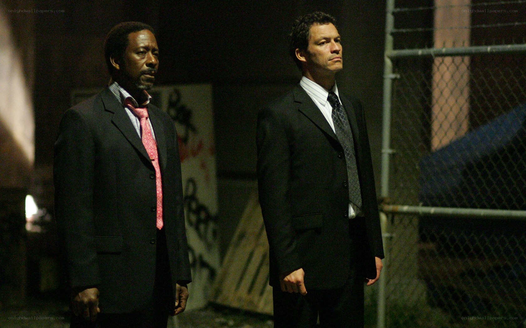 Two men in suits standing at night
