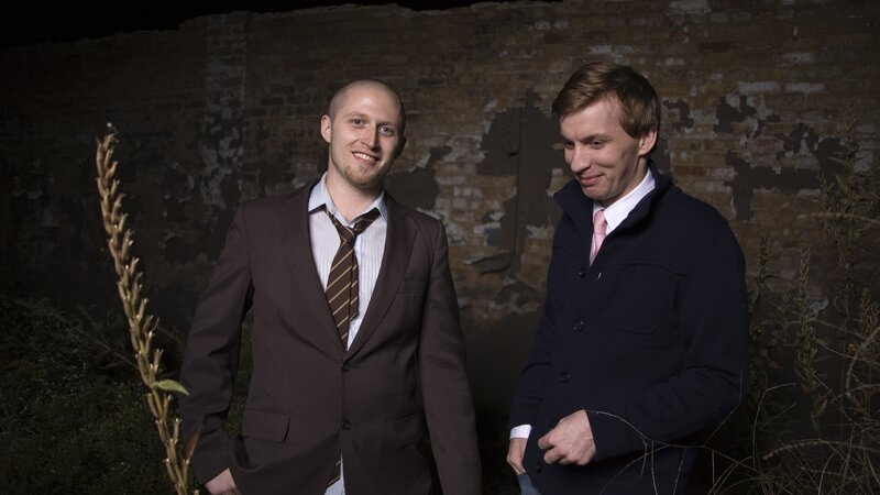 Two men in suits standing outside