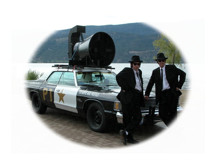 Two men in suits with police car
