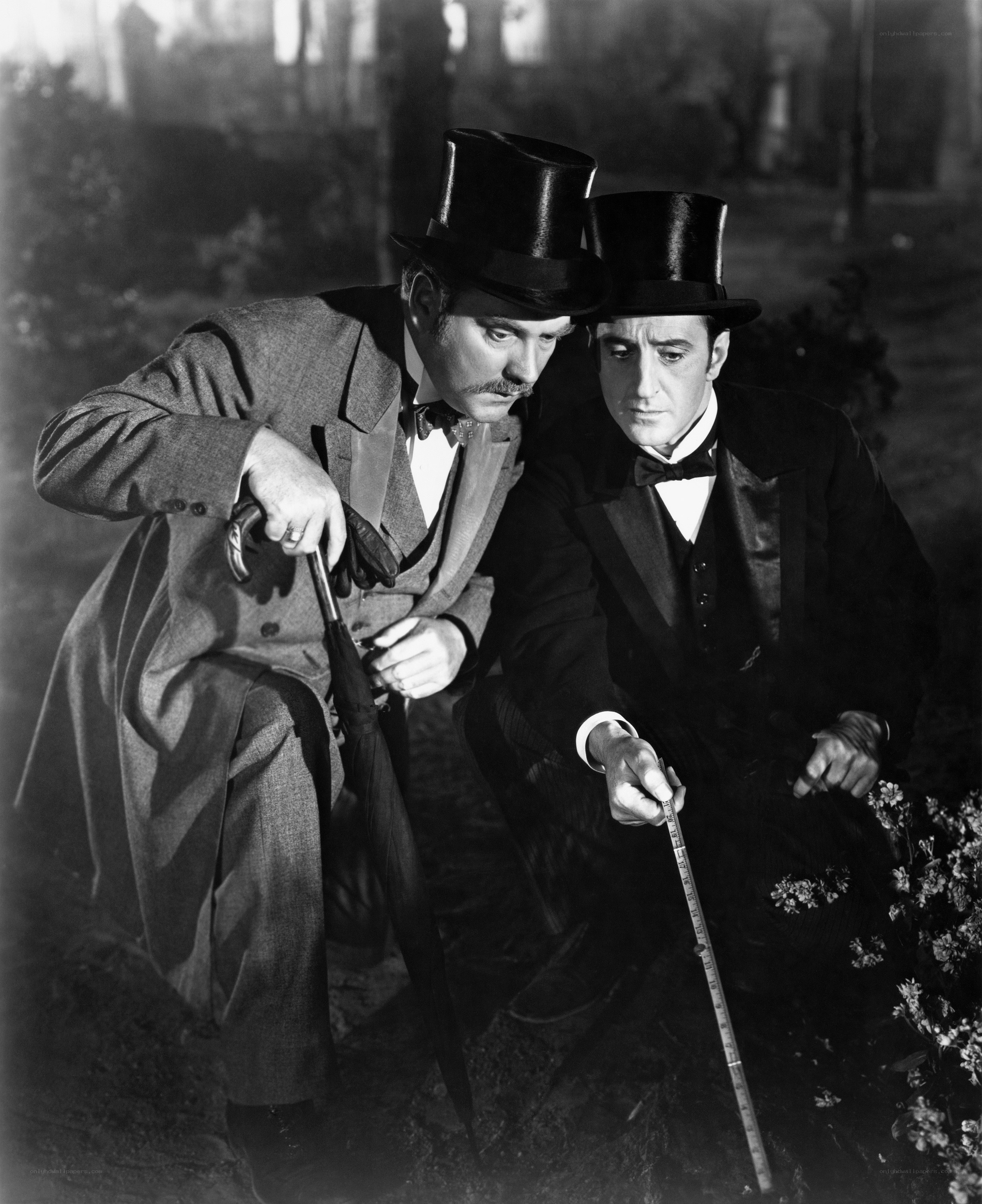 Two men in top hats crouching