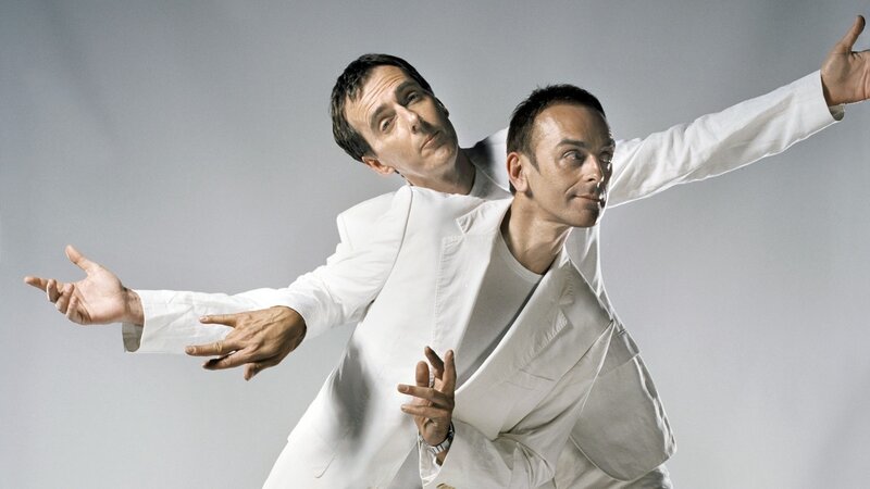 Two men in white suits posing