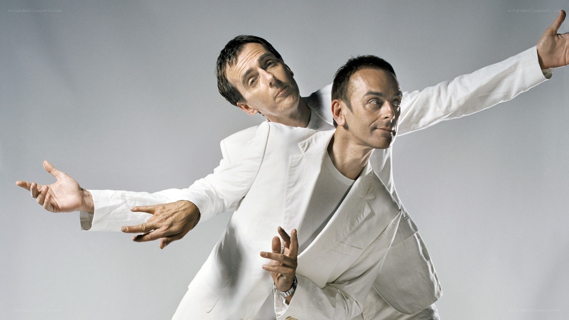 Two men in white suits posing