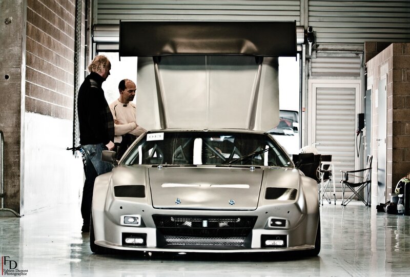 Two men inspecting a race car