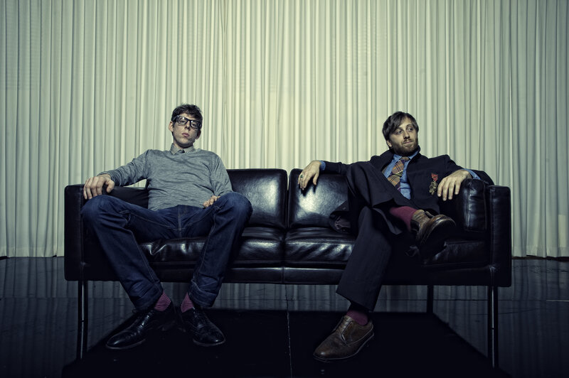 Two men on a black couch