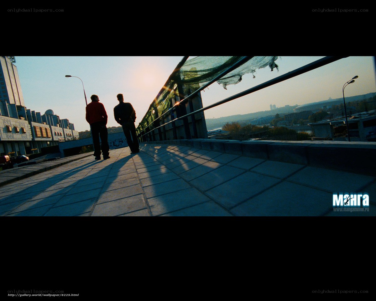Two men on a bridge at sunset