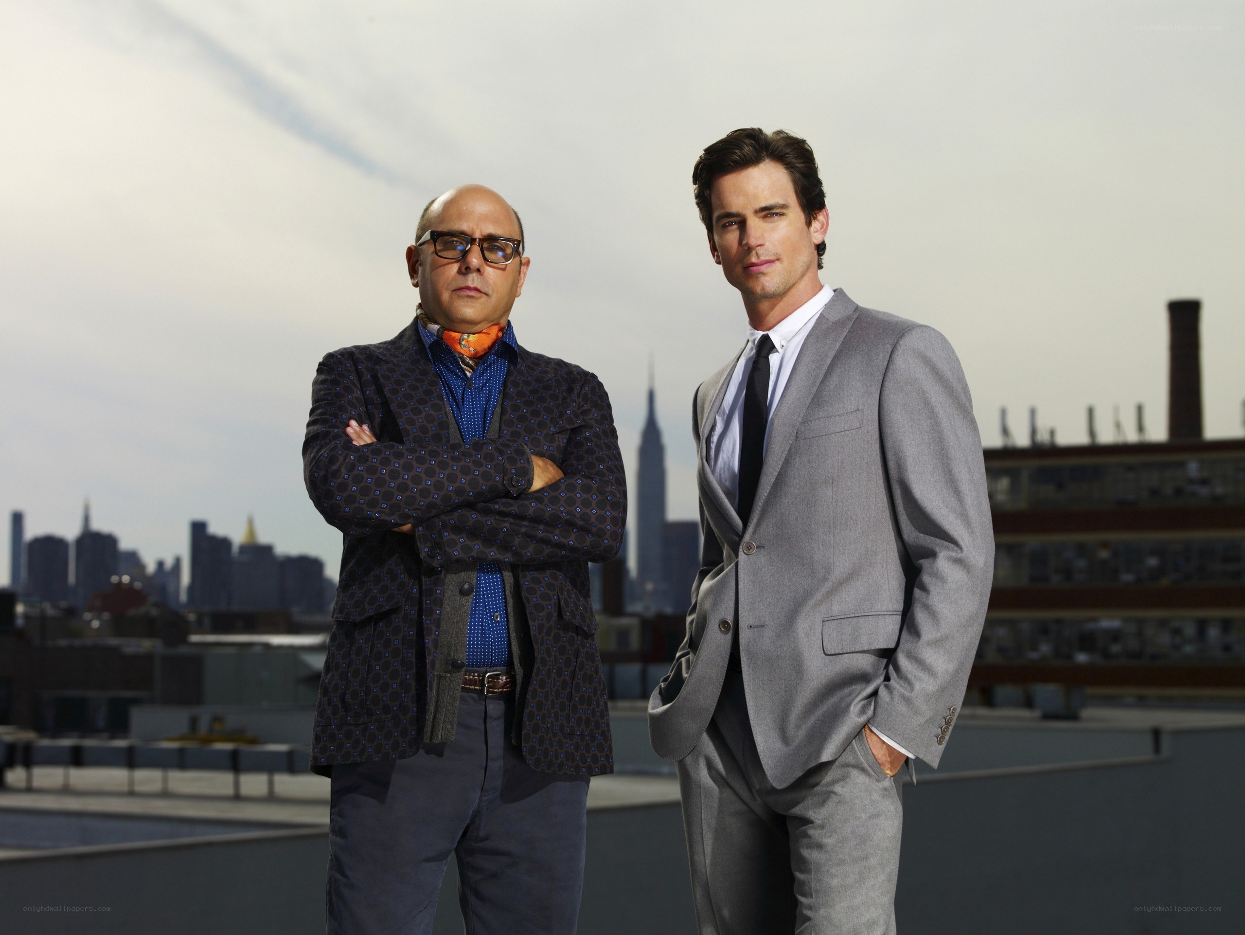 Two men on a rooftop with city view
