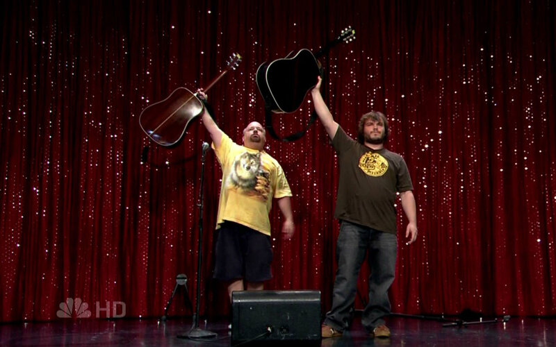 Two men on stage with guitars