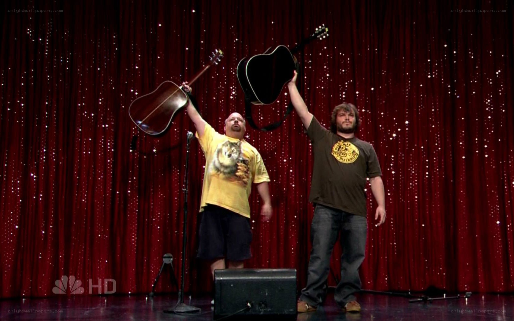 Two men on stage with guitars