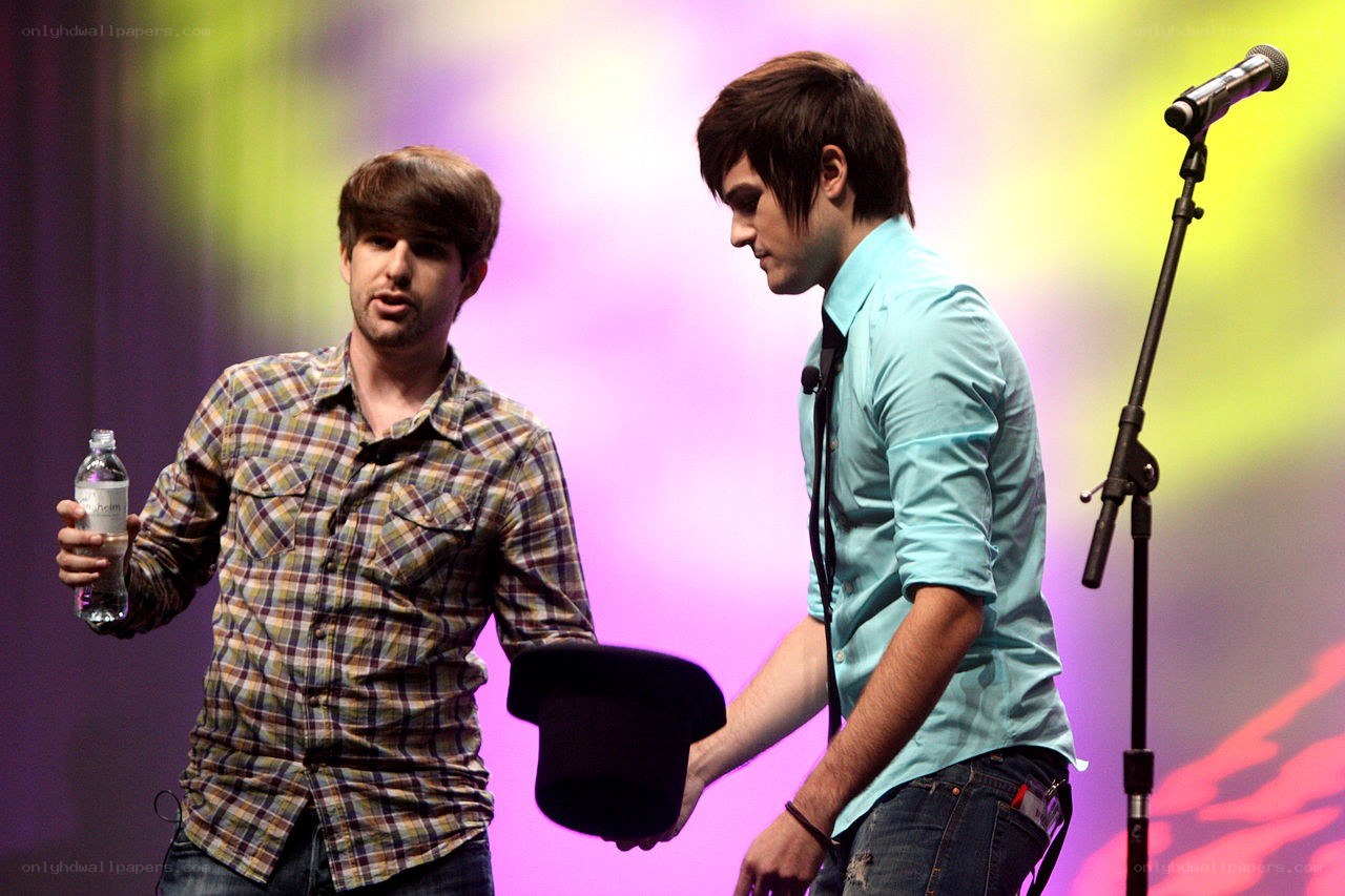 Two men on stage with hats