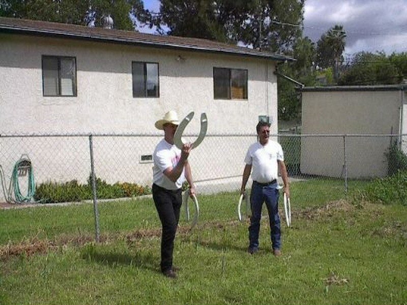 Two men playing horseshoes