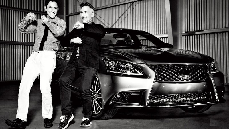 Two men posing with a luxury car
