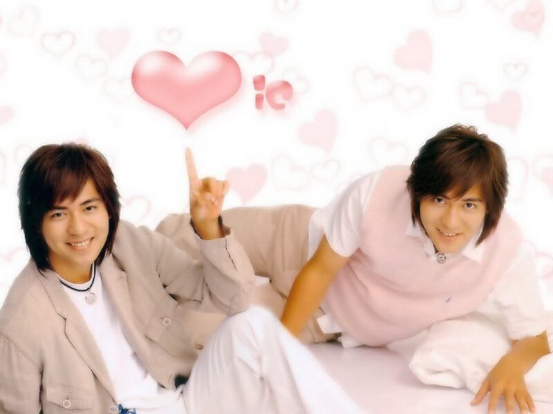 two men posing with hearts