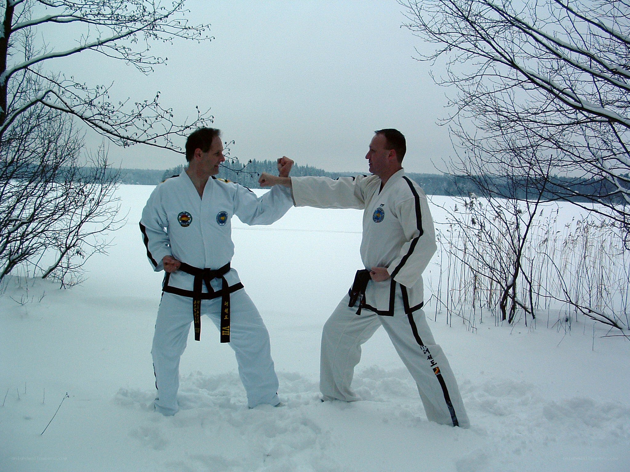 Two men practicing martial arts in snow