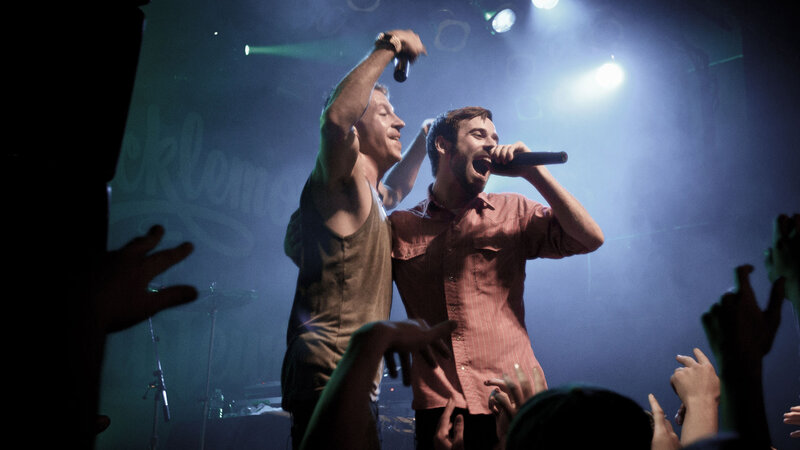 Two Men Singing on Stage — Blue