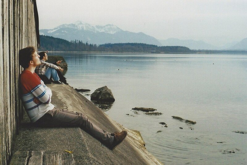 Two men sitting by a lake