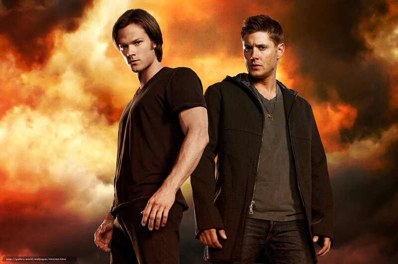 two men standing against fire