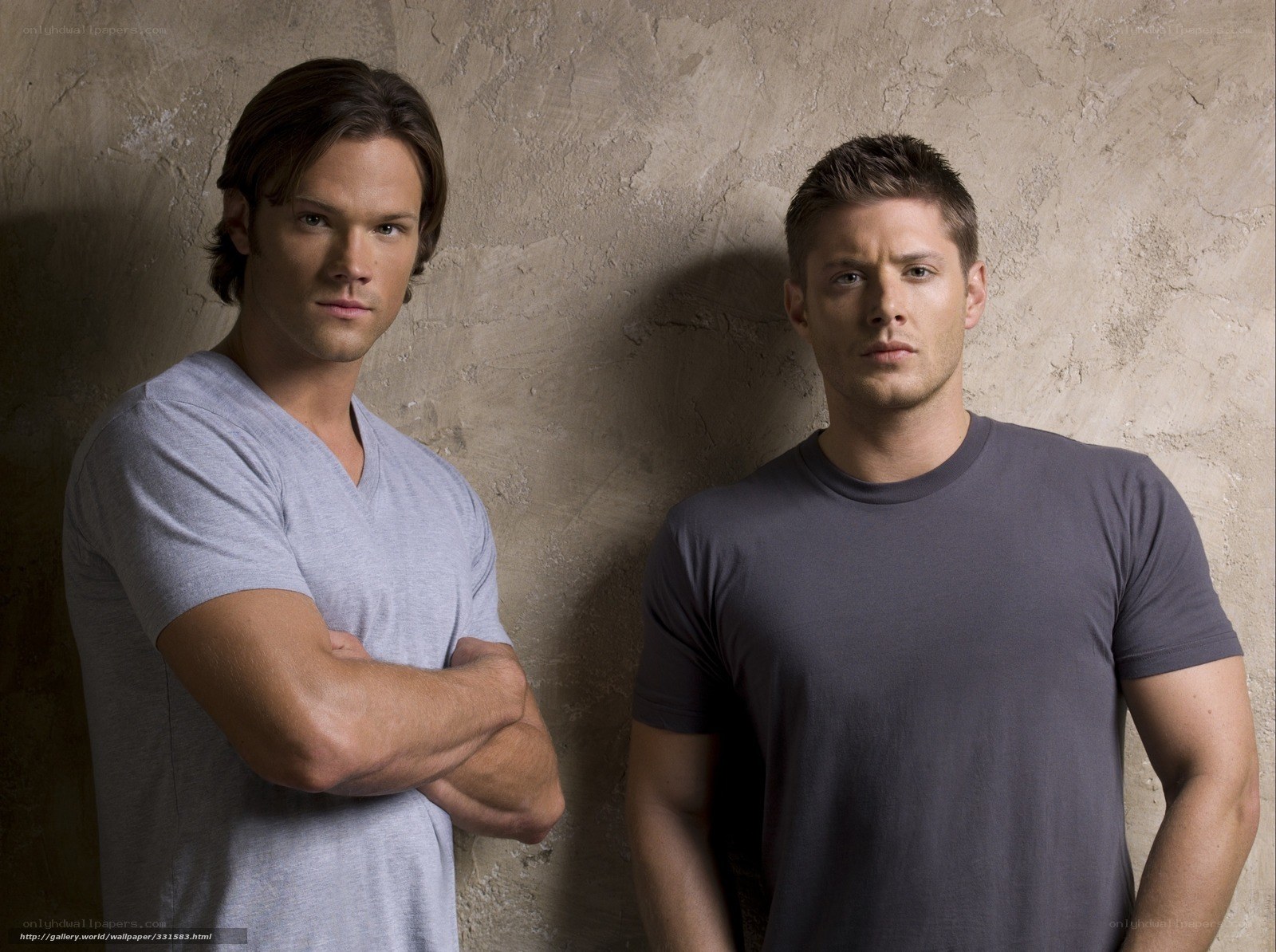 two men standing against wall