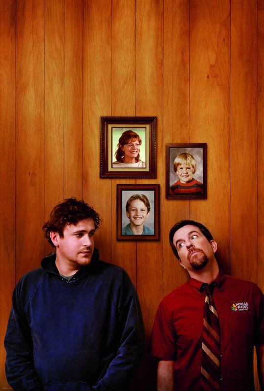 Two men standing by family photos