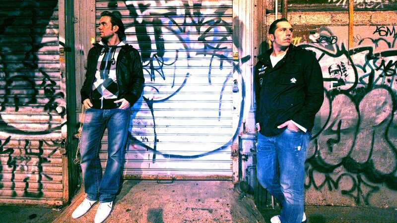 two men standing by graffiti wall
