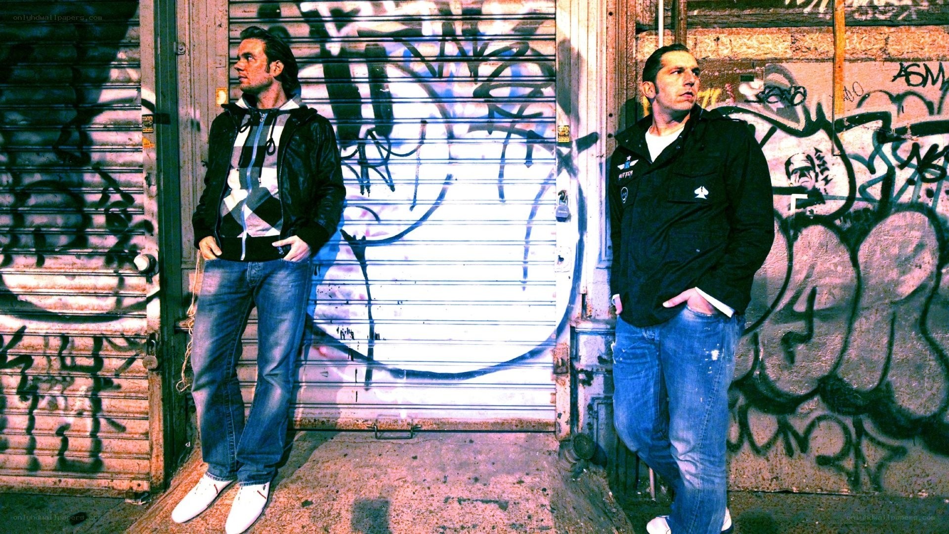 two men standing by graffiti wall