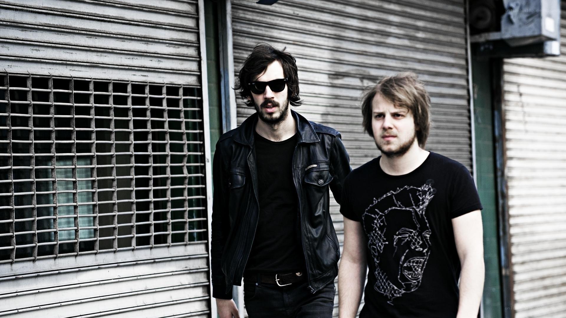 two men standing in front of shuttered building