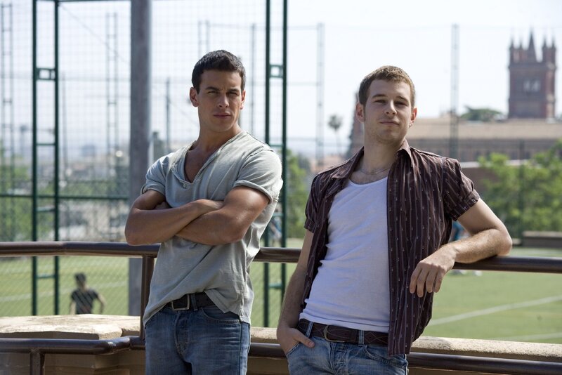 two men standing on a balcony