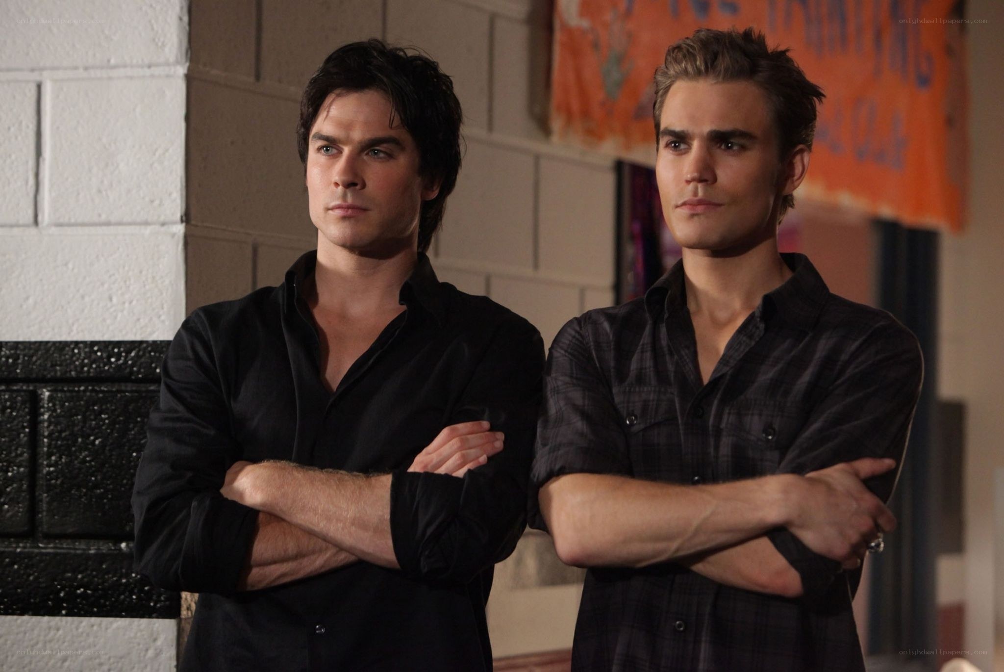 two men standing with arms crossed