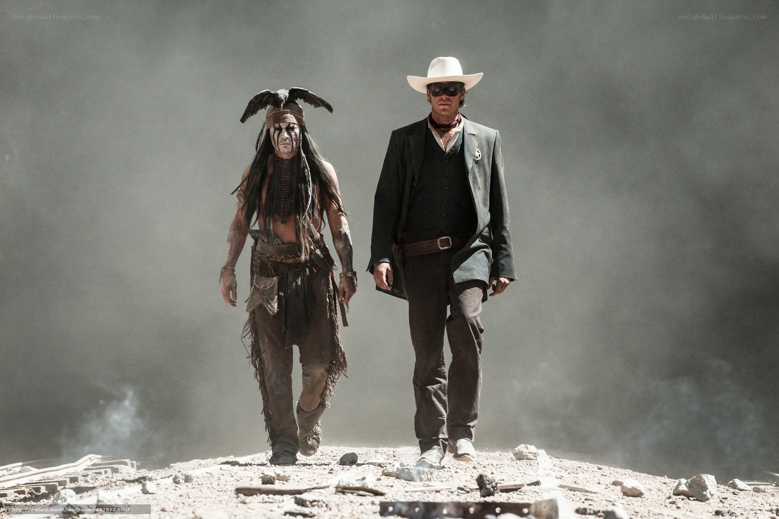 Two men walk through a dusty landscape