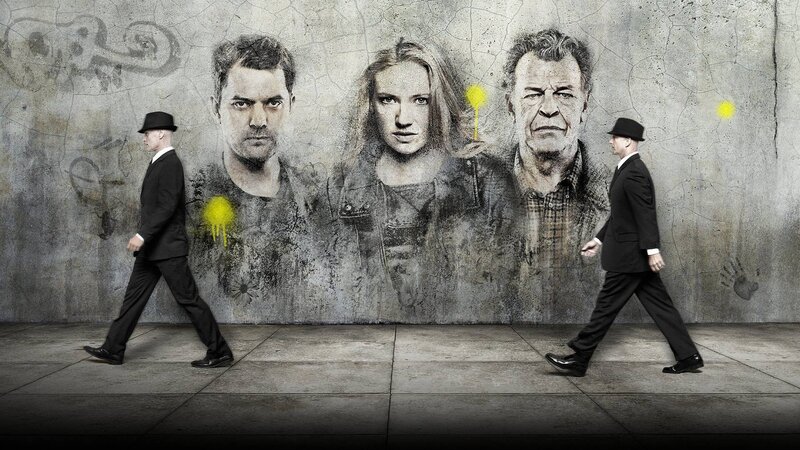 Two Men Walking Past Mural