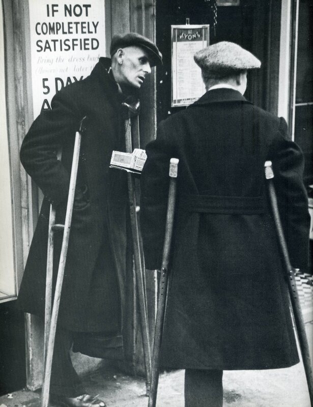 Two men with crutches on a street
