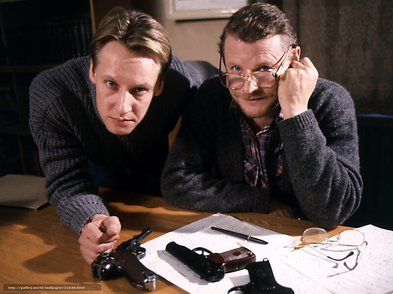 Two men with guns at a table