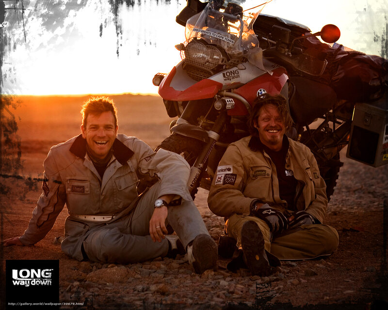 Two men with motorcycle at sunset