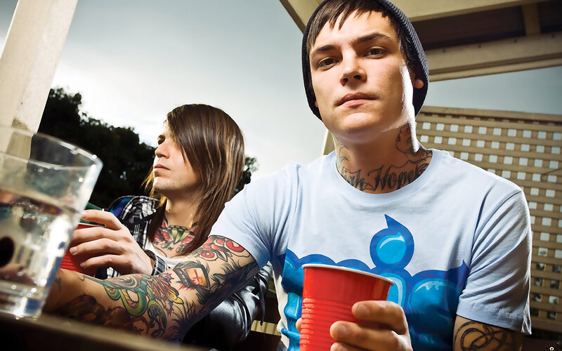 two men with tattoos at a table
