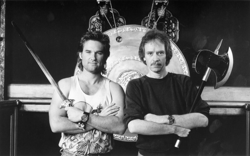 Two men with weapons in front of a shield