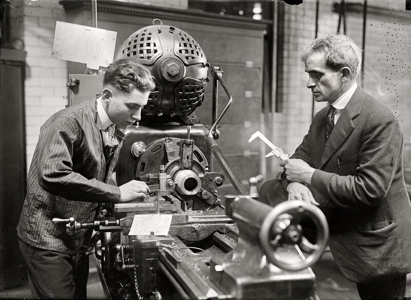 Two men working on a lathe machine