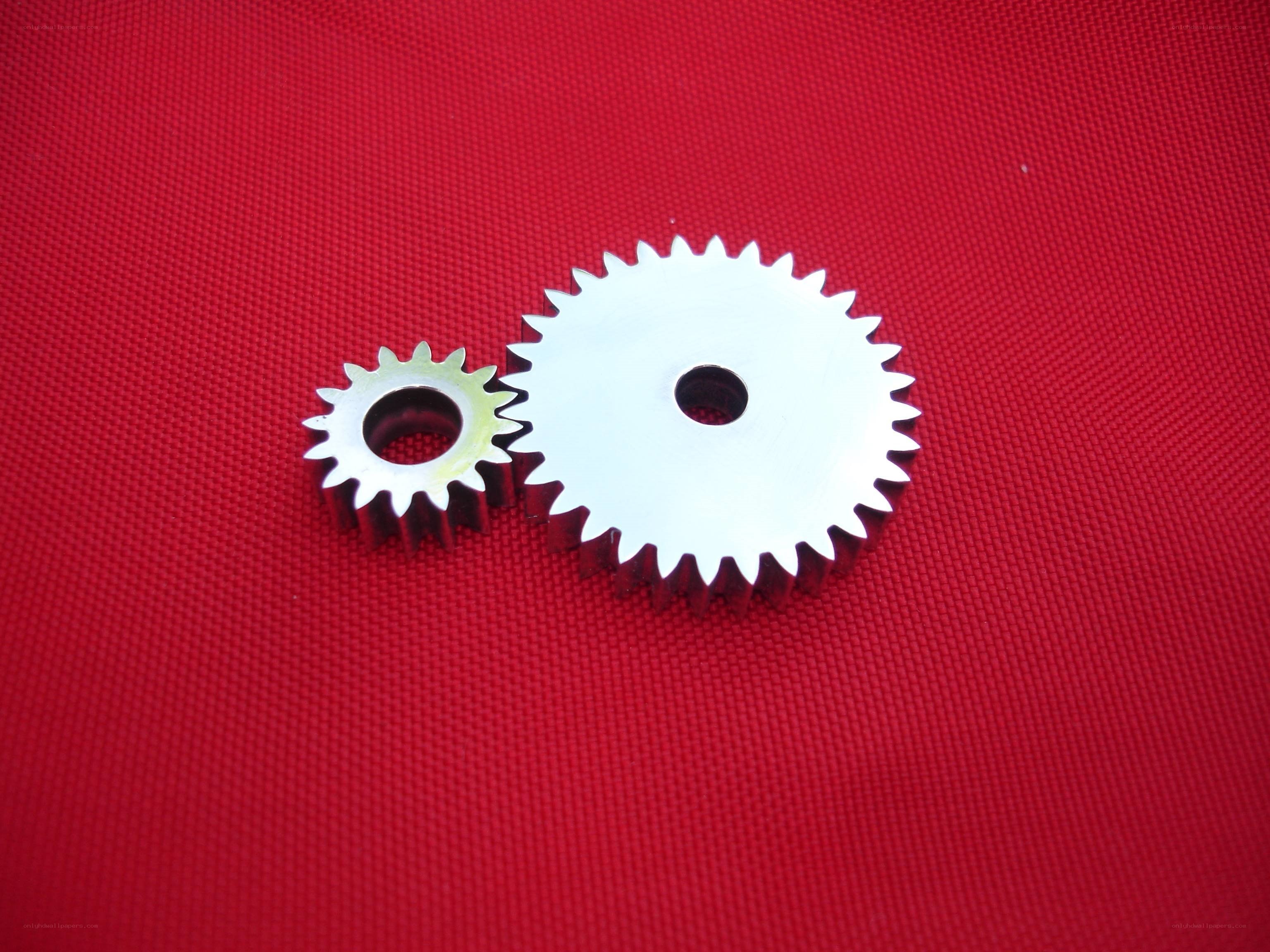Two metal gears on red fabric
