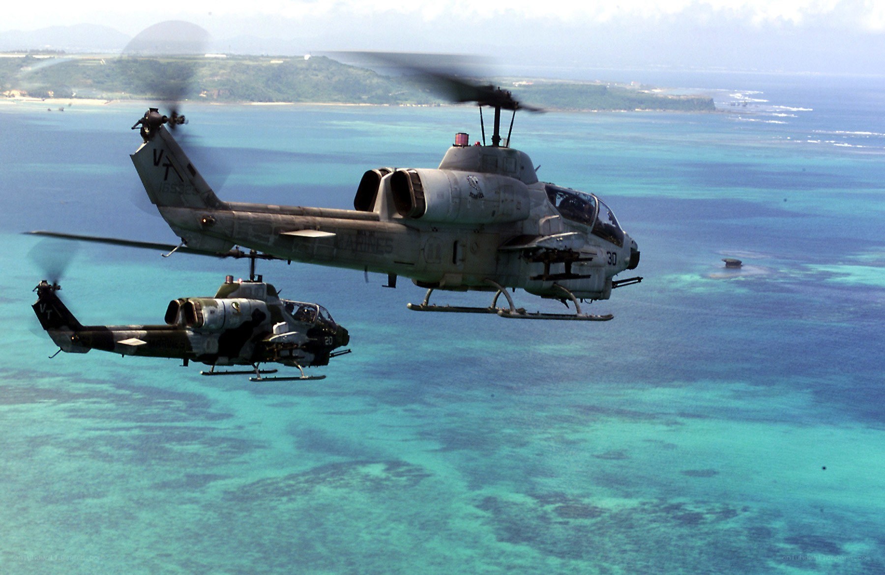 Two military helicopters over ocean